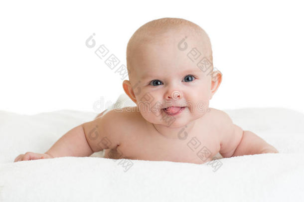 可爱的微笑婴儿露出舌头躺在白色上