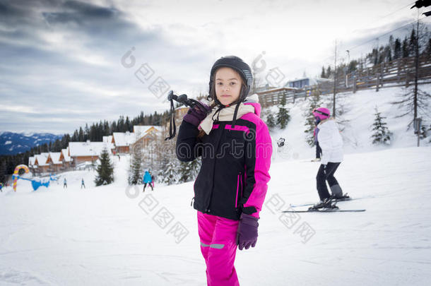 女孩用滑雪设备在滑雪坡上摆姿势