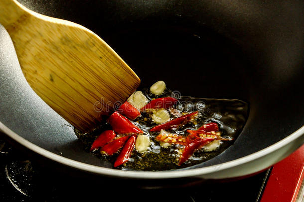 炒大蒜和红冷锅用木勺搅拌