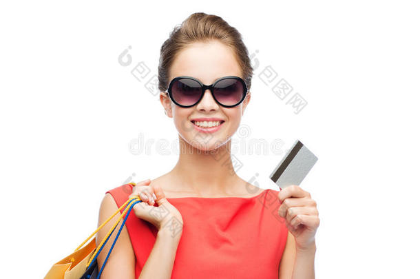 微笑的女人拿着购物袋和塑料卡