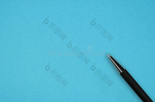 蓝色纸背景上的黑色圆珠笔