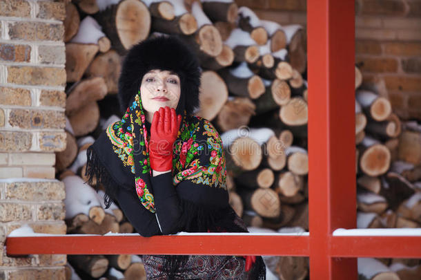 穿着红色手套的漂亮女孩在冬天的阳台上摆姿势