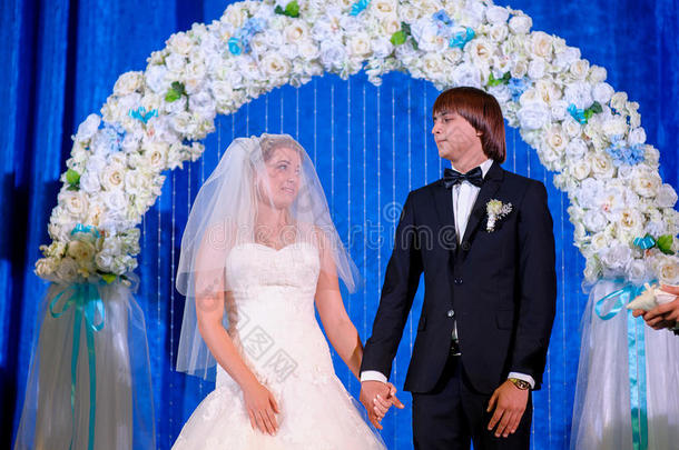 新郎和新娘拿着花束，在婚礼当天摆姿势。 享受片刻的幸福和爱