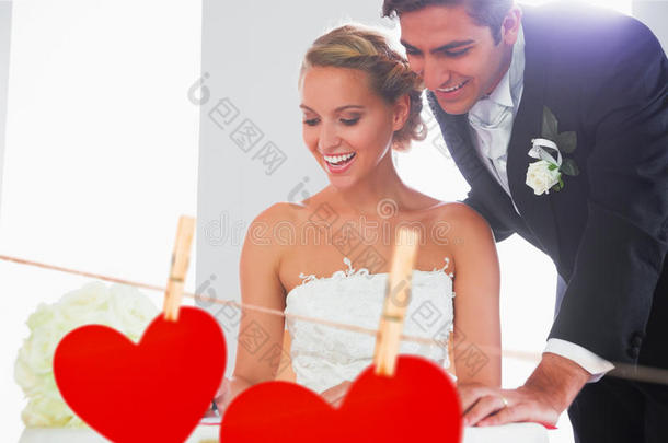 幸福年轻夫妇签署婚礼登记册的复合图像
