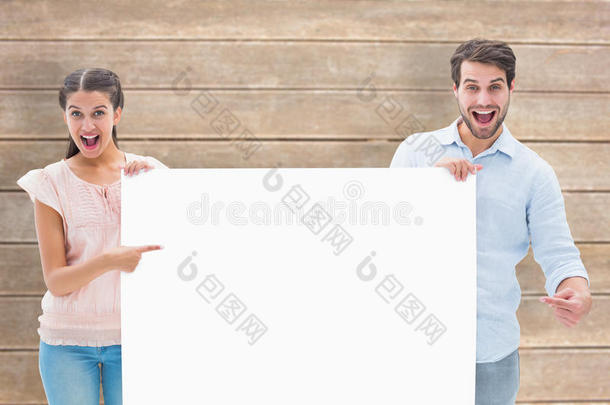 有吸引力的年轻夫妇微笑着拿着海报的复合图像