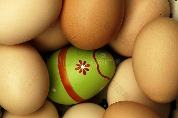 五颜六色的复活节彩蛋在普通鸡蛋的<strong>陪伴</strong>下。