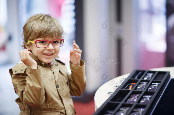 一个可爱的小男孩在眼镜店挑选他的新眼镜
