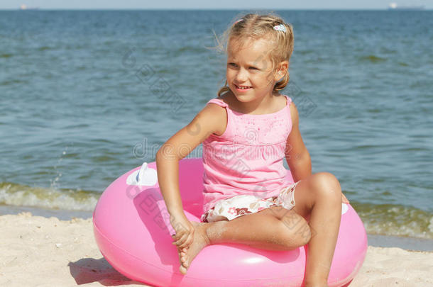 孩子坐在一个圆圈上，在海边游泳