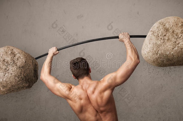 肌肉发达的男子举起大石头重物