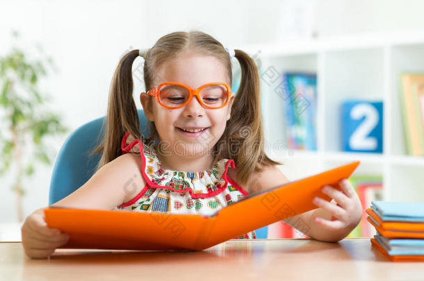 快乐有趣戴眼镜的小女孩看书