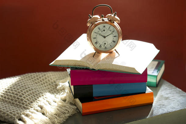 睡前阅读，闹钟和床头柜上的书
