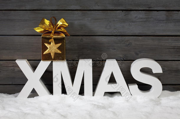 大写字母构成了“圣诞节”这个词，上面有星星形状的装饰，在木墙上堆着一堆雪