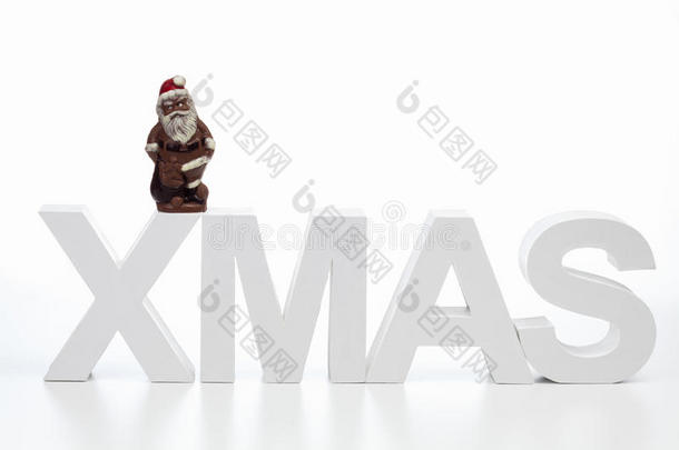 大写字母组成的单词圣诞节与巧克力圣诞老人在中间的白色背景