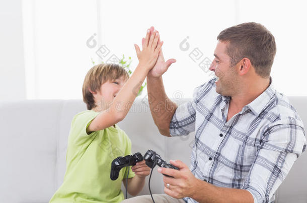父子俩在玩电子游戏的时候给击掌