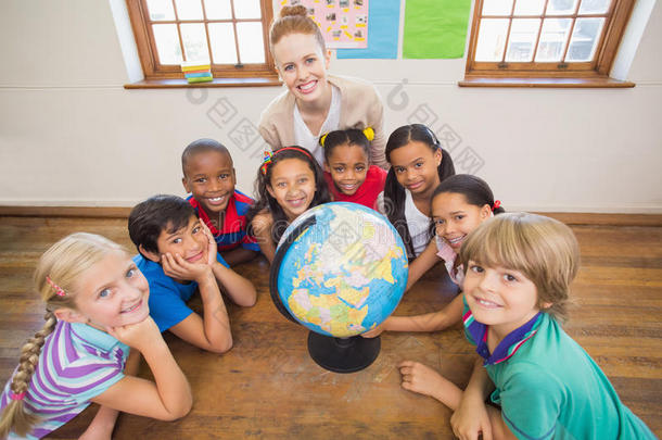 可爱的学生和老师在教室里用地球仪