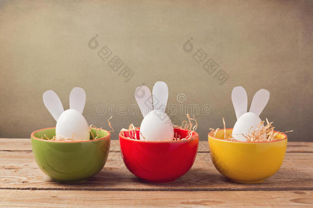 复活节假期鸡蛋，兔子耳朵在木桌上