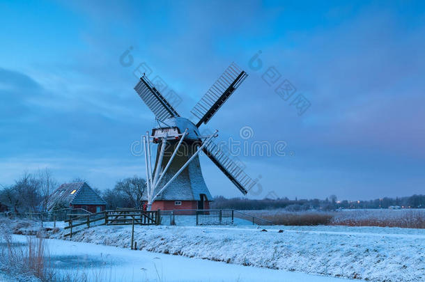 日出时雪中的荷兰风车