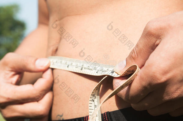 健身者测量他的身体。 裁剪和中段图像的