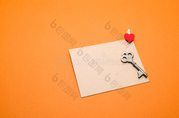 信封的心脏和钥匙在橙色的背景上。