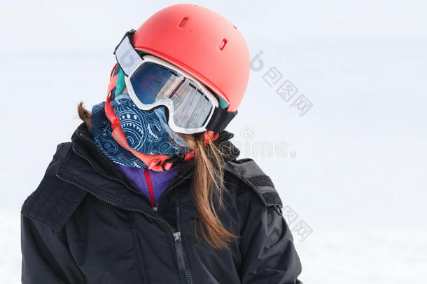 女孩滑雪者用头盔包裹着温暖的滑雪用具