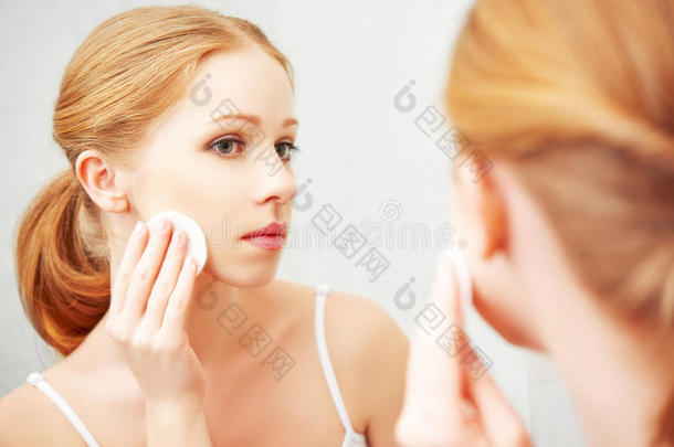 美丽的年轻女人用面部皮肤卸妆