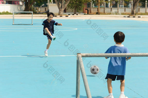 男孩在蓝色地板上踢足球