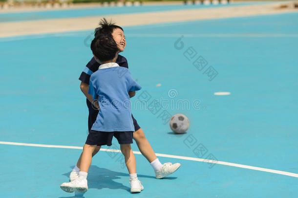 男孩在蓝色地板上踢足球