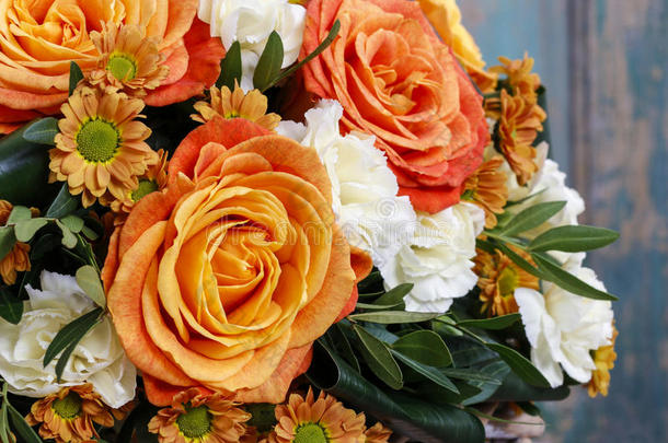 一束橙色玫瑰和象牙康乃馨花