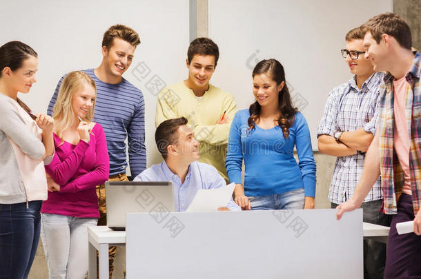 一群学生和老师拿着笔记本电脑