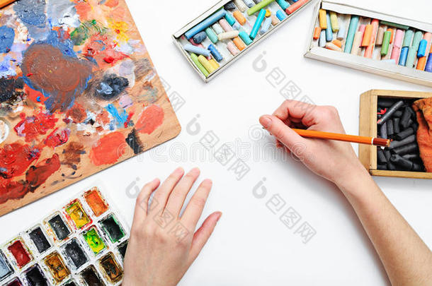 艺术家的手在工作，油漆，刷子和铅笔