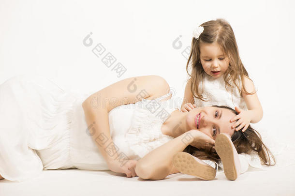 美丽的小女孩在白色的背景上拥抱她的母亲