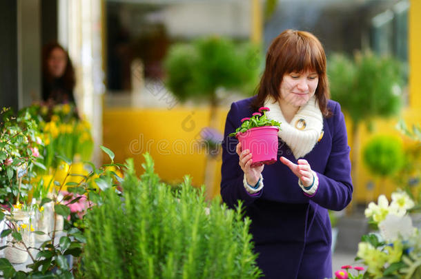 美丽的女人在花卉市场选花