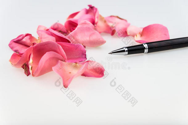 黑色圆珠笔，白色背景上有浅粉色玫瑰花瓣