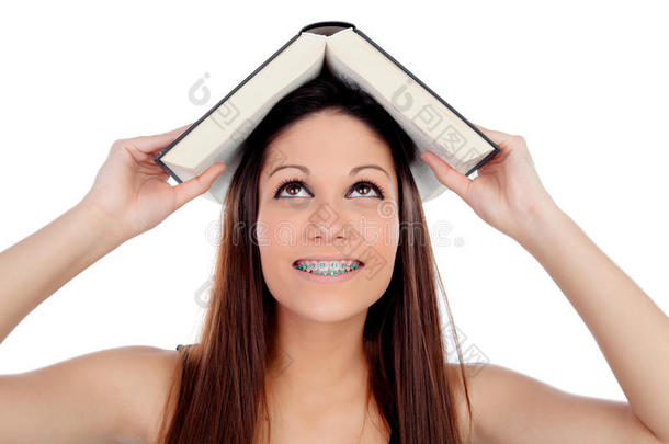 有吸引力的学生女人带着括号，头上有一本书