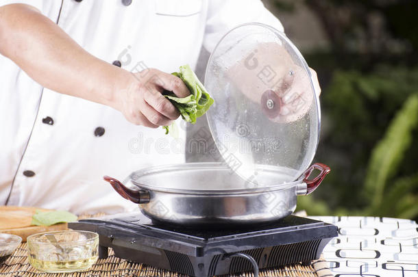 厨师在煮面条之前把蔬菜放在锅里