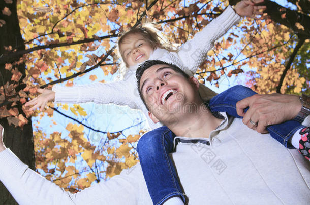 一家人在秋天的公园里享受金色的叶子