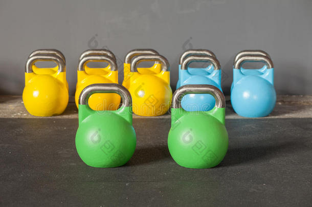 在健身房里一排五颜六色的水壶铃-把注意力集中在前面的水壶铃上