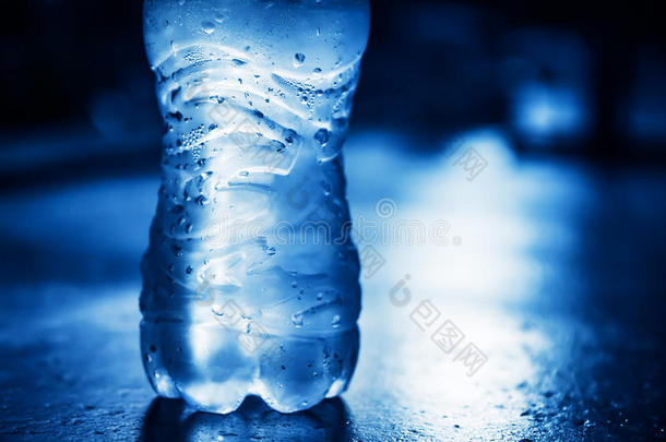 一瓶带有凝结水滴和背光的纯净水