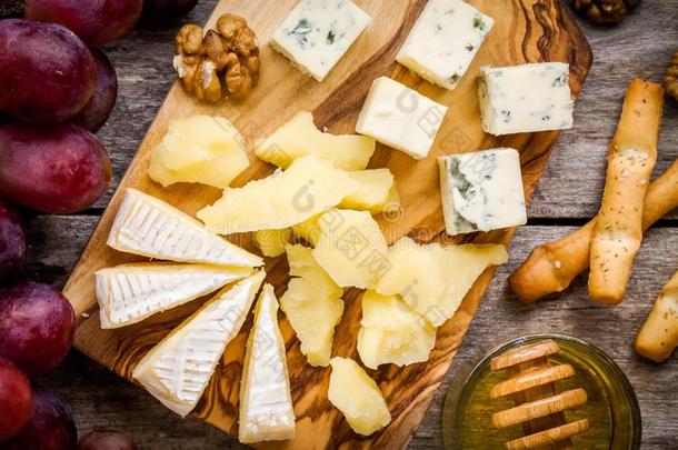 奶酪盘：卡曼伯特奶酪，蓝色奶酪特写，面包棒，核桃，蜂蜜，葡萄