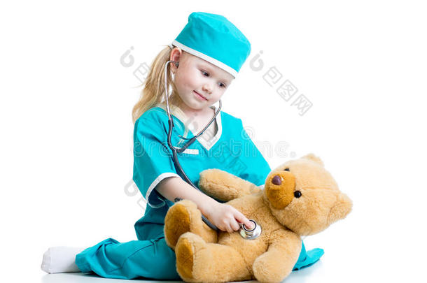 可爱的孩子穿着医生的衣服检查泰迪熊玩具