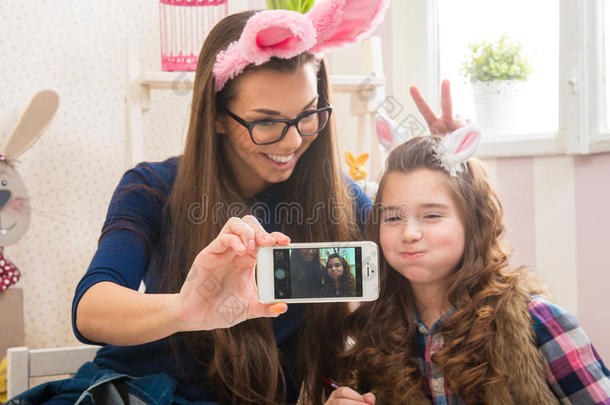 复活节-妈妈和女儿用兔子的耳朵，拍了自拍照片