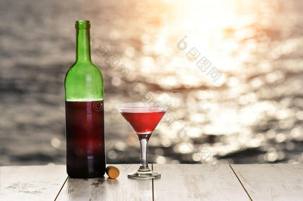 日落时，亚麻布桌上的一瓶<strong>红酒</strong>和一杯<strong>红酒</strong>，靠在大海或海洋上