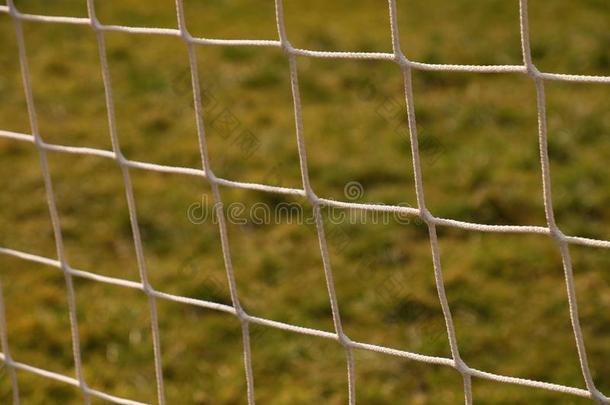 详细的交叉足球网，足球足球在球门网与天然草在足球操场的背景