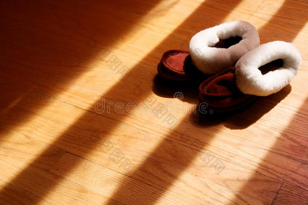 婴儿冬季拖鞋在硬木地板上