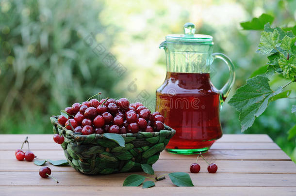冷爽的饮料，从樱桃在水罐和成熟的浆果在篮子在木制桌子上