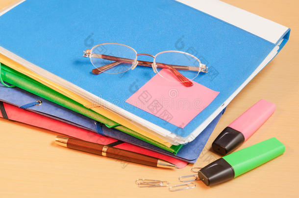 一组五颜六色的办公文件夹，眼镜和办公用品