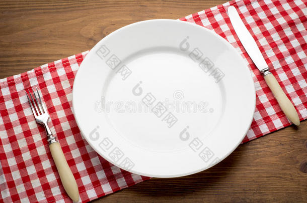 在红上的木桌上空的白色盘子