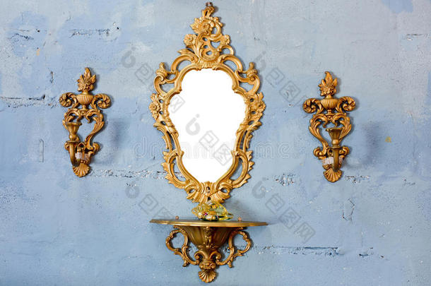 金色的老式镜子，墙上有金色的烛台