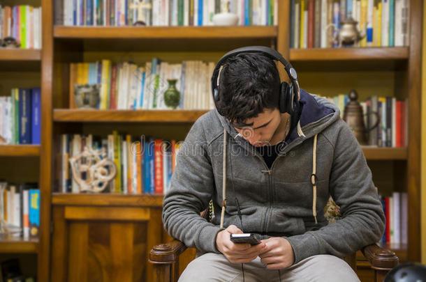 有吸引力的年轻人坐在一套立体声耳机上听音乐