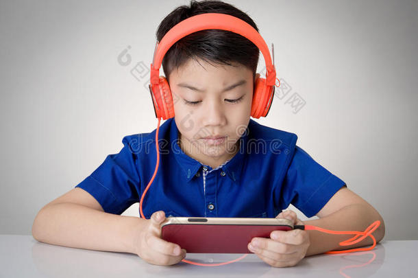 亚洲男孩准备耳机和玩手机